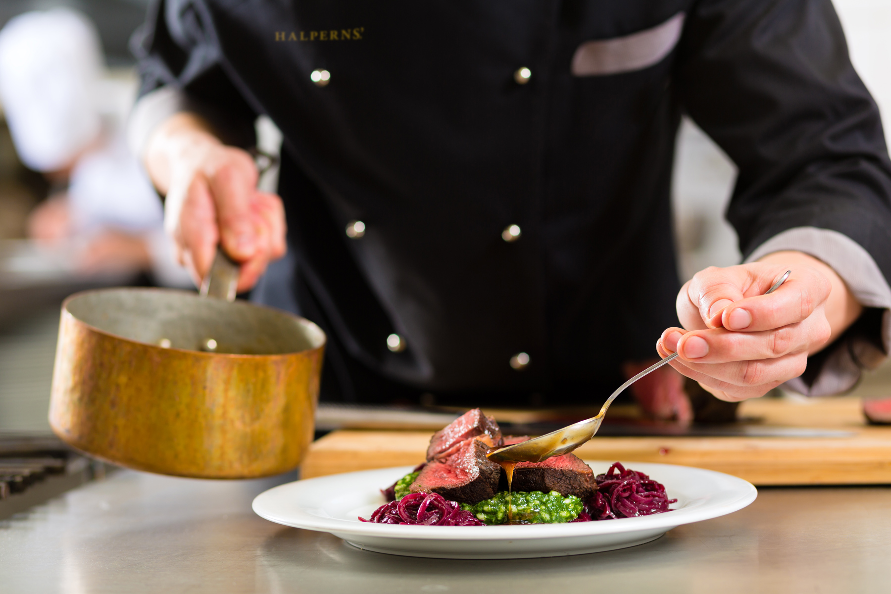 Chef showcasing culinary skills with premium Halperns' steak, highlighting excellence in the foodservice industry.