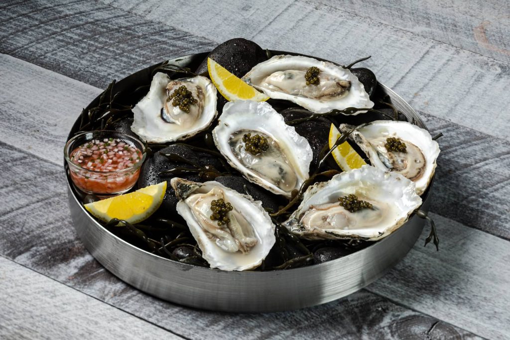 Platter of oysters on the half shell topped with caviar